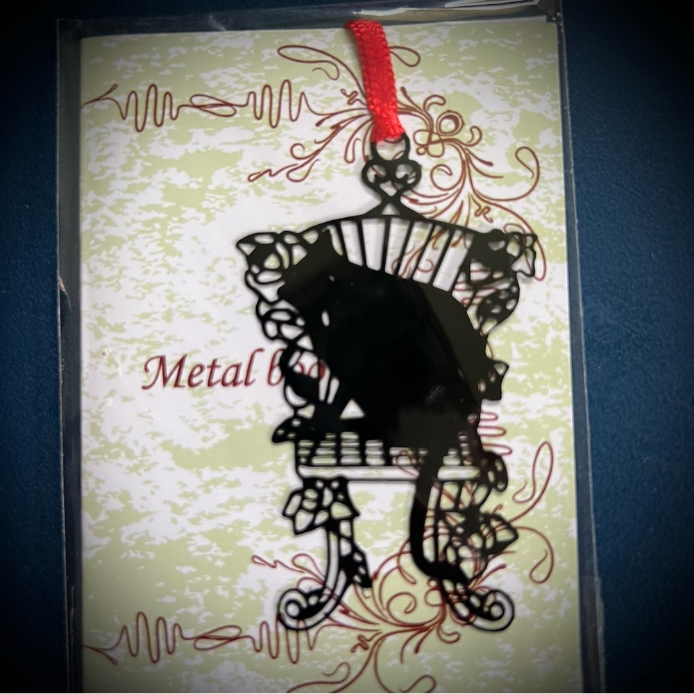 Black cat on garden seat metal ornament or bookmark with red ribbon